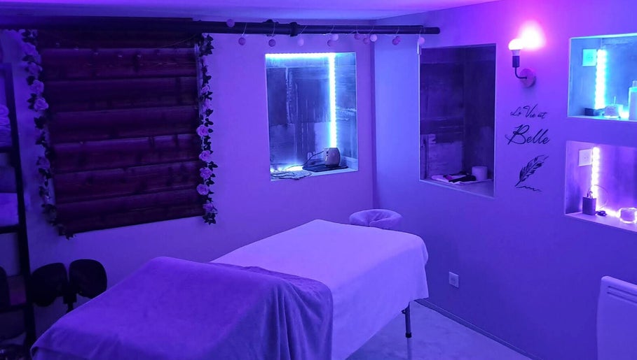 Salon de massage bleu-violet à Aux Mains D'Adeline, Raves, Grand Est, FR, offrant une ambiance relaxante.