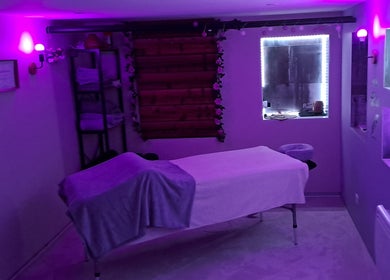 Salle de soins apaisante à Aux Mains D'Adeline, Raves, Grand Est, FR, éclairée de lumières douces violettes.