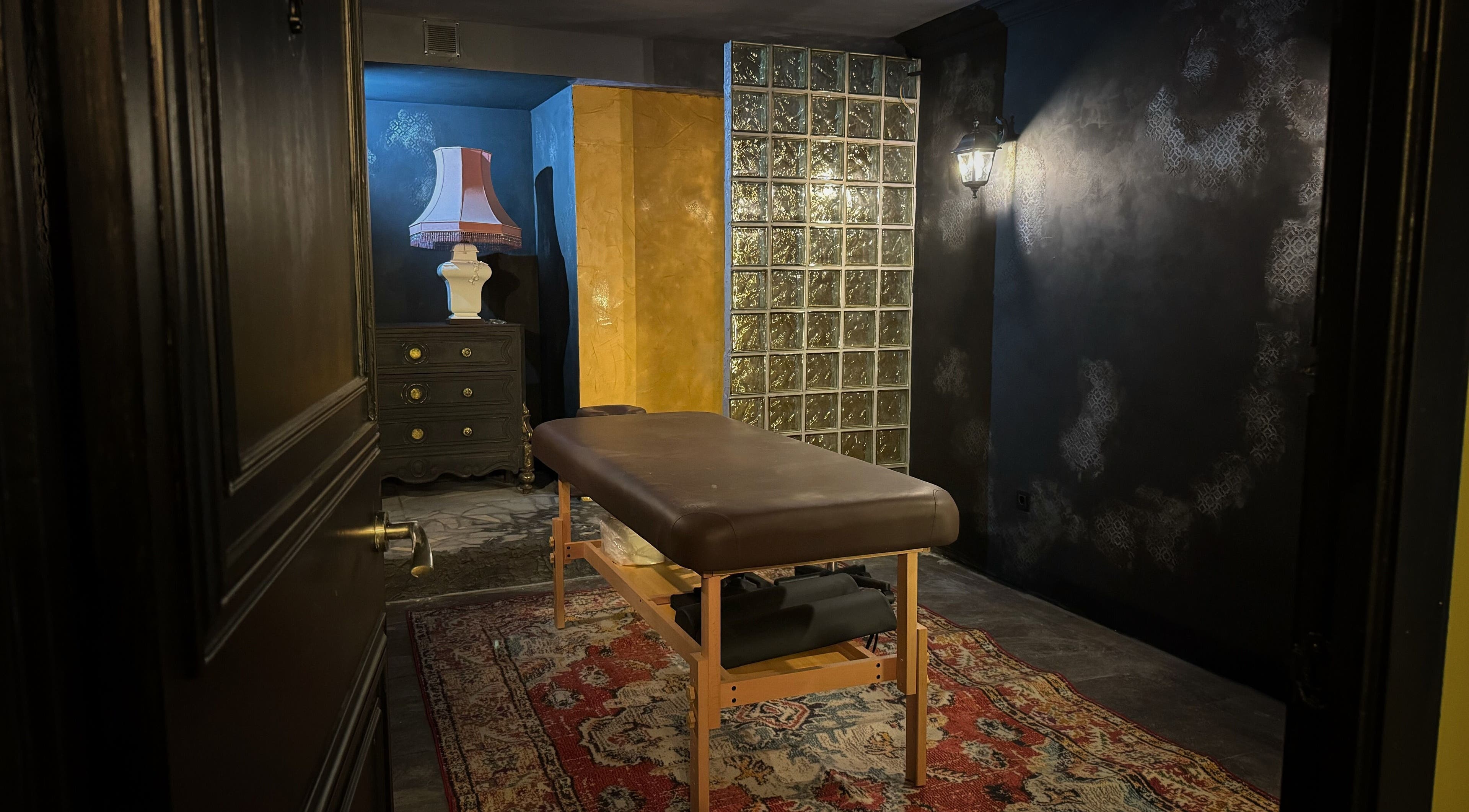 Inviting massage room at Confession massage studio, Barcelona, Catalunya, ES, with warm lighting and elegant decor.
