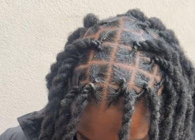 Intricate dreadlock style at HairbyQ in London, England, GB showcasing detailed braiding.