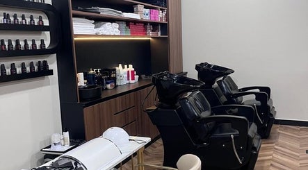Modern salon wash area at Nisantasi Ladies Salon LLC, Dubai, AE, showcasing sleek black chairs and premium products.