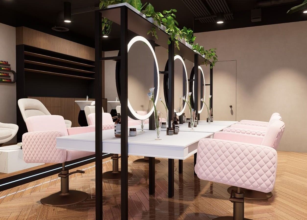 Chic interior of Nisantasi Ladies Salon LLC in Dubai, AE with modern mirrors and pink quilted chairs.
