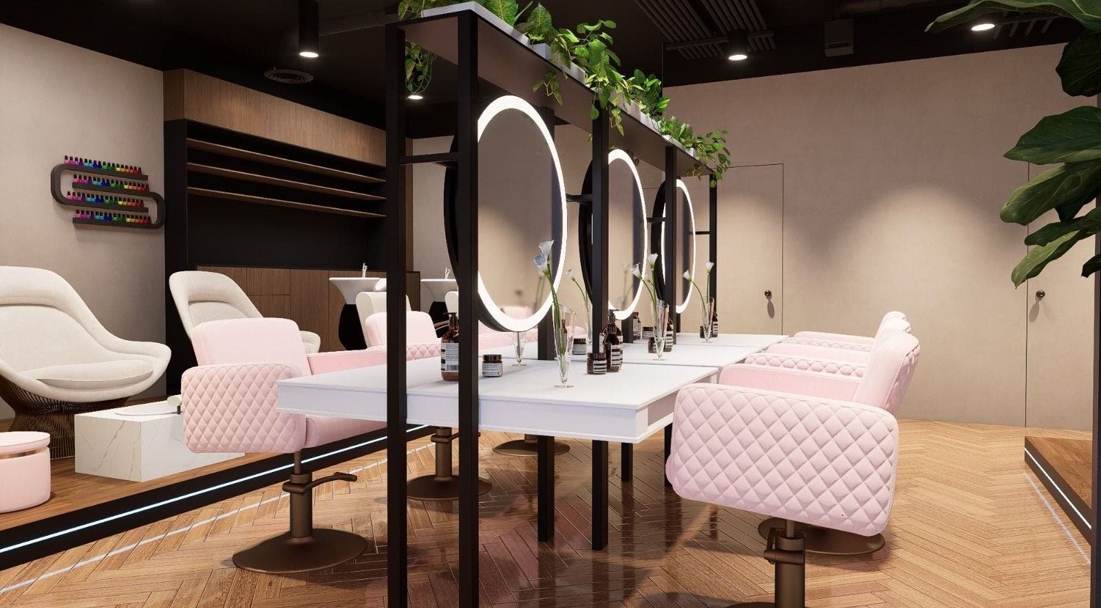 Chic interior of Nisantasi Ladies Salon LLC in Dubai, AE with modern mirrors and pink quilted chairs.