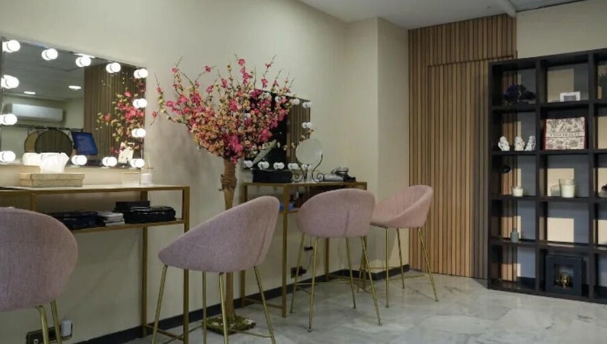 Elegante salón de belleza en Inés Sánchez Beauty Concept, Granada, Andalucía, ES con sillas rosadas y espejo iluminado.