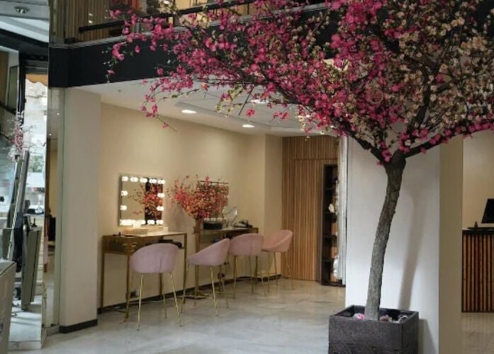 Interior elegante de Inés Sánchez Beauty Concept en Granada, Andalucía, ES, con decoración floral y asientos confortables.