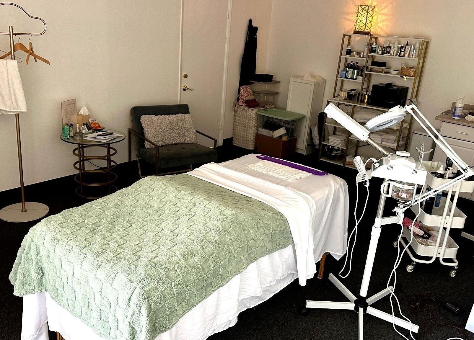 Cozy treatment room at Lash & Glow by Oana, Newport Beach, California, US with bed and equipment.