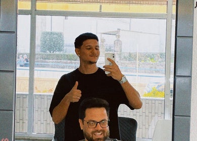 Cliente satisfeito na Machado’s Barbershop em Braga, Braga, PT, mostrando sinal de positivo.