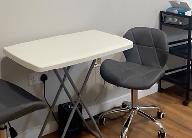 Modern seating area at Prism Aesthetics & Wellness in London, England, GB featuring gray chairs and white table.