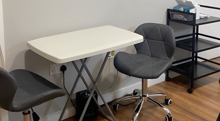 Modern seating area at Prism Aesthetics & Wellness in London, England, GB featuring gray chairs and white table.