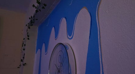 Mural azul vibrante en Soft Skin Studio, Coto Laurel, Ponce, PR con hojas decorativas.