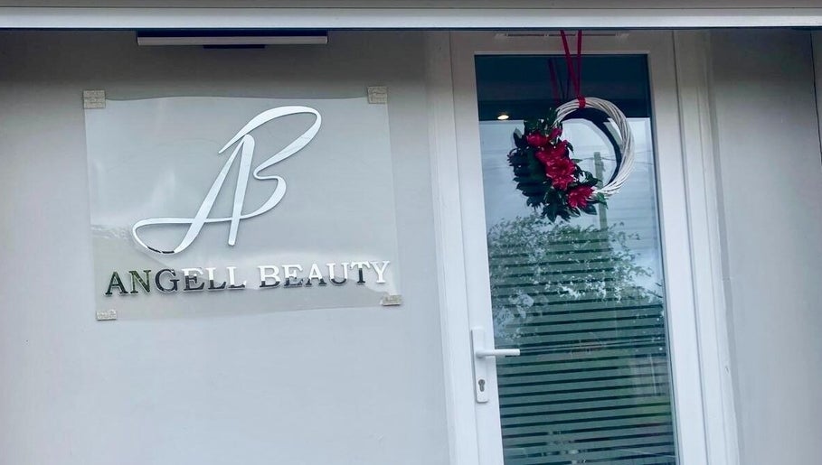 Wejście do Angell Beauty w Radcliffe, Anglia, GB z eleganckim logo i dekoracyjnym wieńcem.