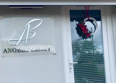 Wejście do Angell Beauty w Radcliffe, Anglia, GB z eleganckim logo i dekoracyjnym wieńcem.
