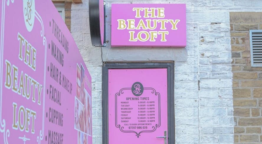 Vibrant pink entrance of The Beauty Loft, Bradford, England, GB, showcasing services and opening hours.