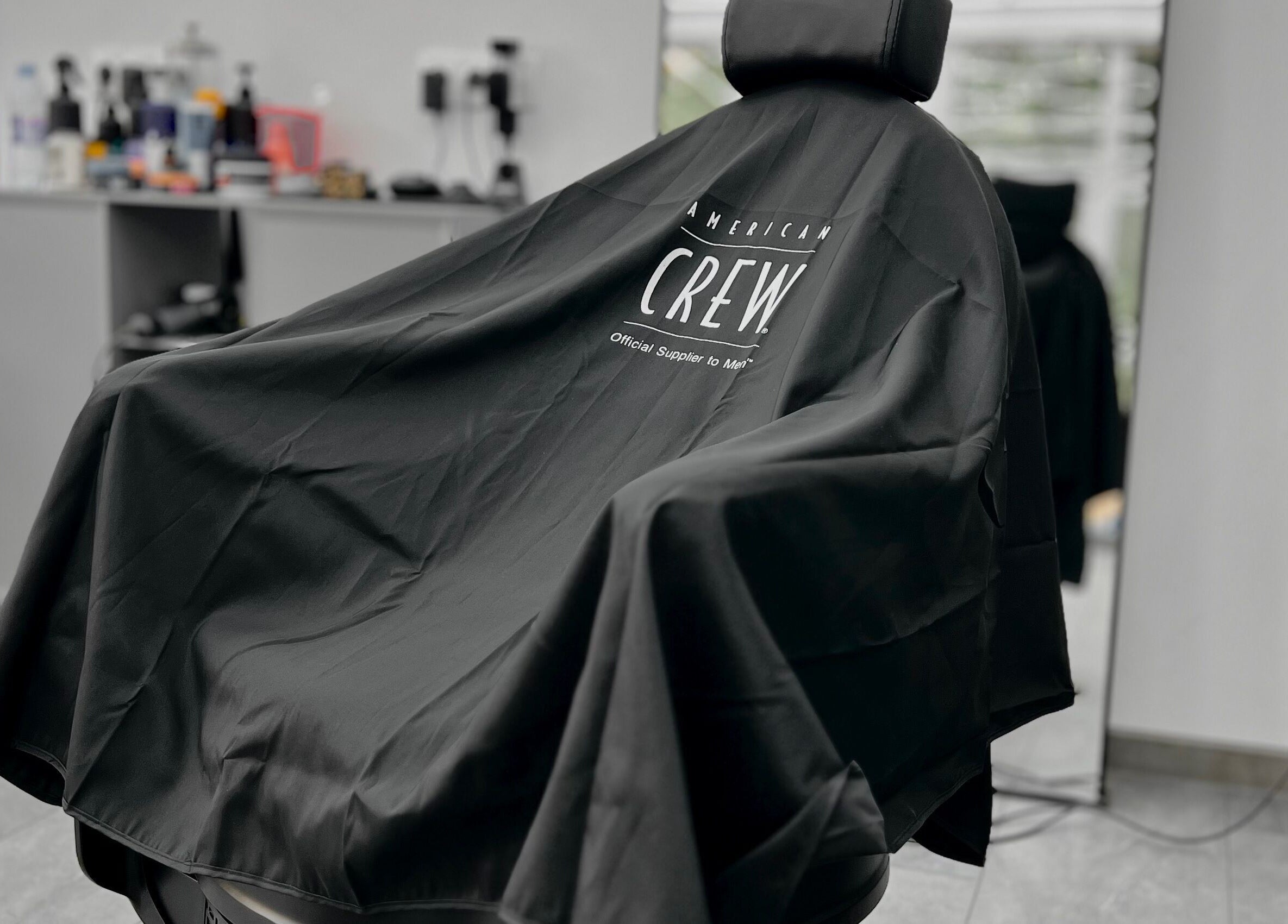 Интериор на DIVO barberstudio в Бургас, Бургас, BG, със стилен стол и козметичен фон.