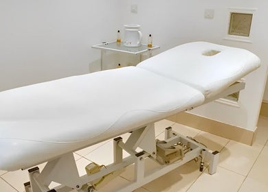 Serene treatment room at Lisa Harris Skin Science, Weybridge, England, GB, featuring a plush white therapy bed.