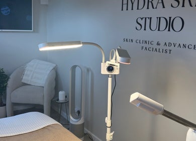 Relaxing treatment room at HYDRASKIN STUDIO, London, England, GB, featuring modern equipment and cozy seating.