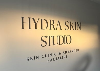 Warmly lit HYDRASKIN STUDIO sign in London, England, GB, showcasing a skin clinic and facialist.