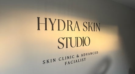 Warmly lit HYDRASKIN STUDIO sign in London, England, GB, showcasing a skin clinic and facialist.
