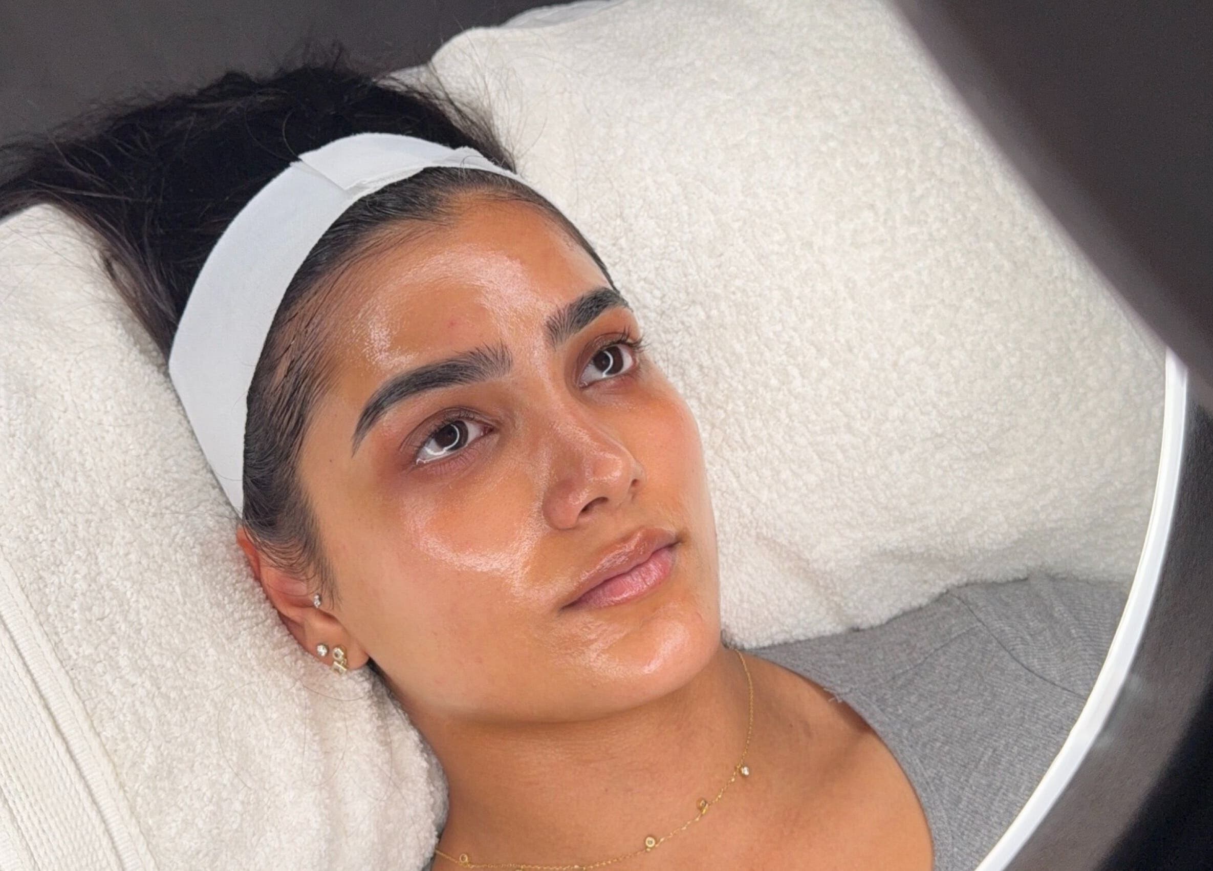 Relaxing facial treatment at HYDRASKIN STUDIO, London, England, GB, showing a woman with glowing skin.