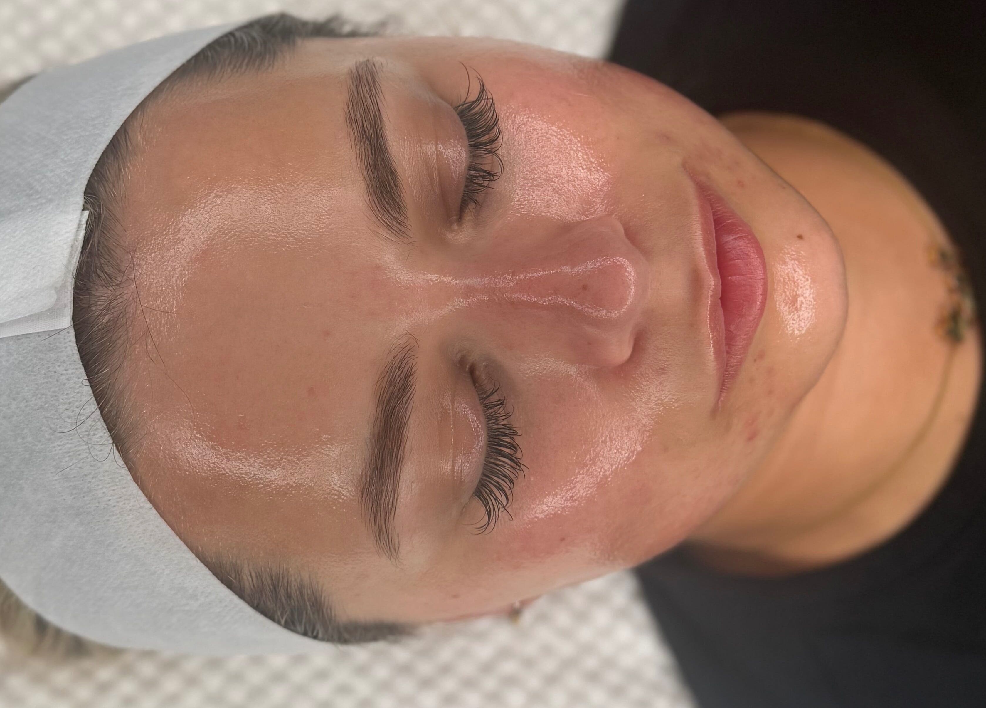 Relaxed client enjoys facial at HYDRASKIN STUDIO in London, England, highlighting glowing skin results.