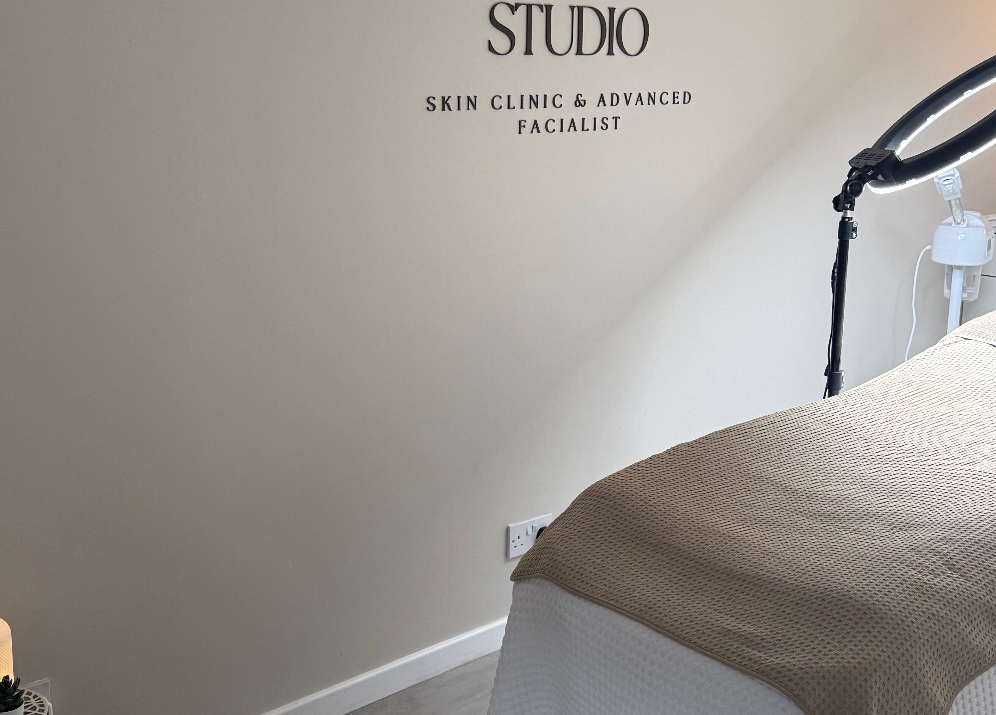 Tranquil therapy room at HYDRASKIN STUDIO, London, England, GB, showcasing a cozy treatment bed and ambient lighting.
