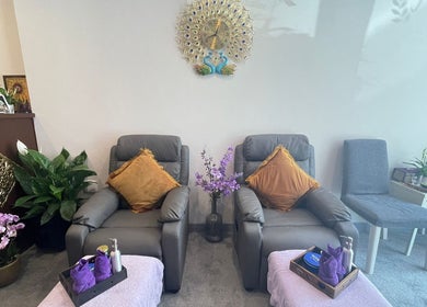 Ontspanruimte bij Malee Thai Massage, Zandvoort, Noord-holland, NL met comfortabele stoelen en bloemen.
