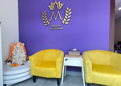 Ontspannende wachtruimte bij Malee Thai Massage in Zandvoort, Noord-holland, NL, met gele stoelen en paarse muur.