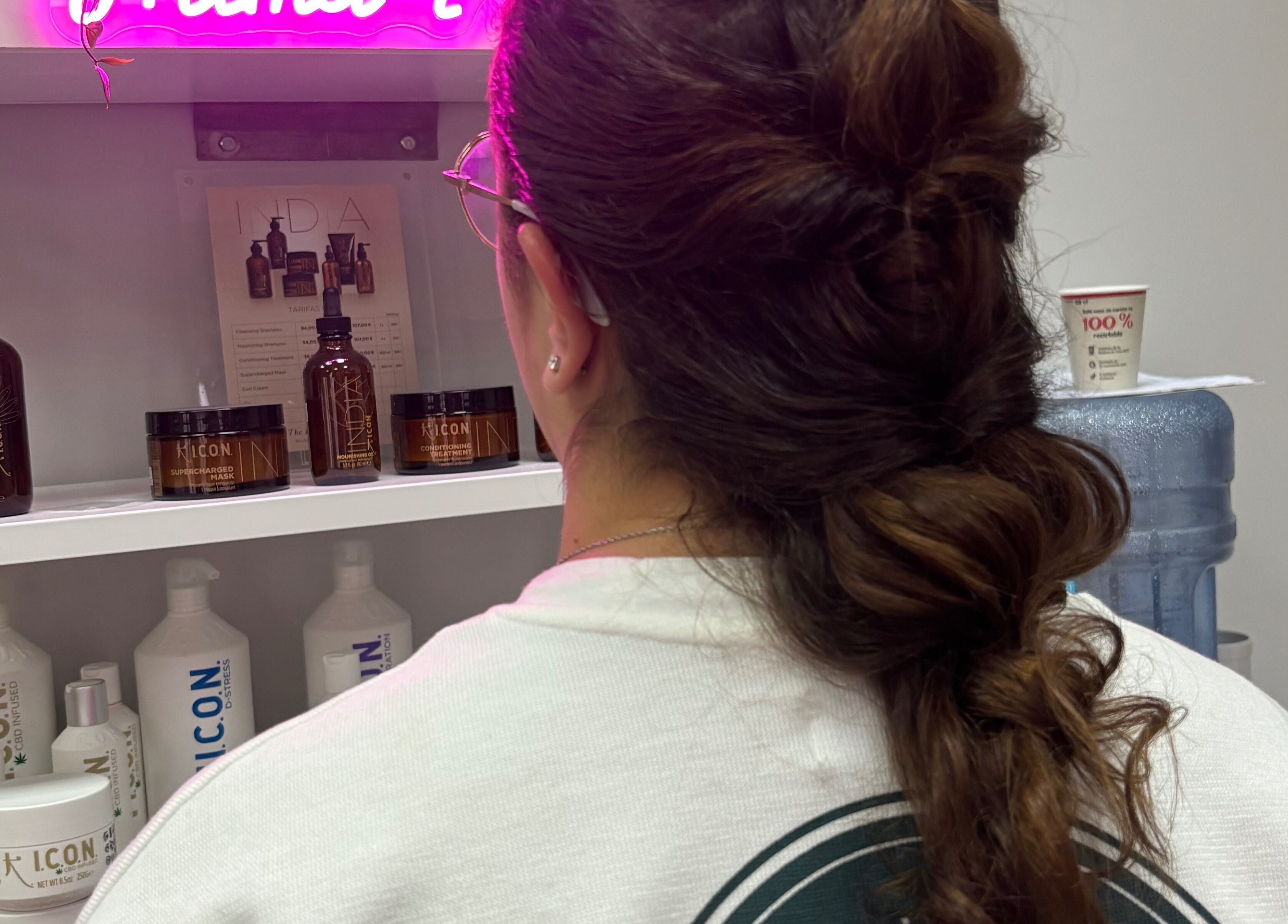 Mujer con elegante peinado frente a productos de belleza en Mima-T, Tarancón, Castilla-la Mancha, ES.