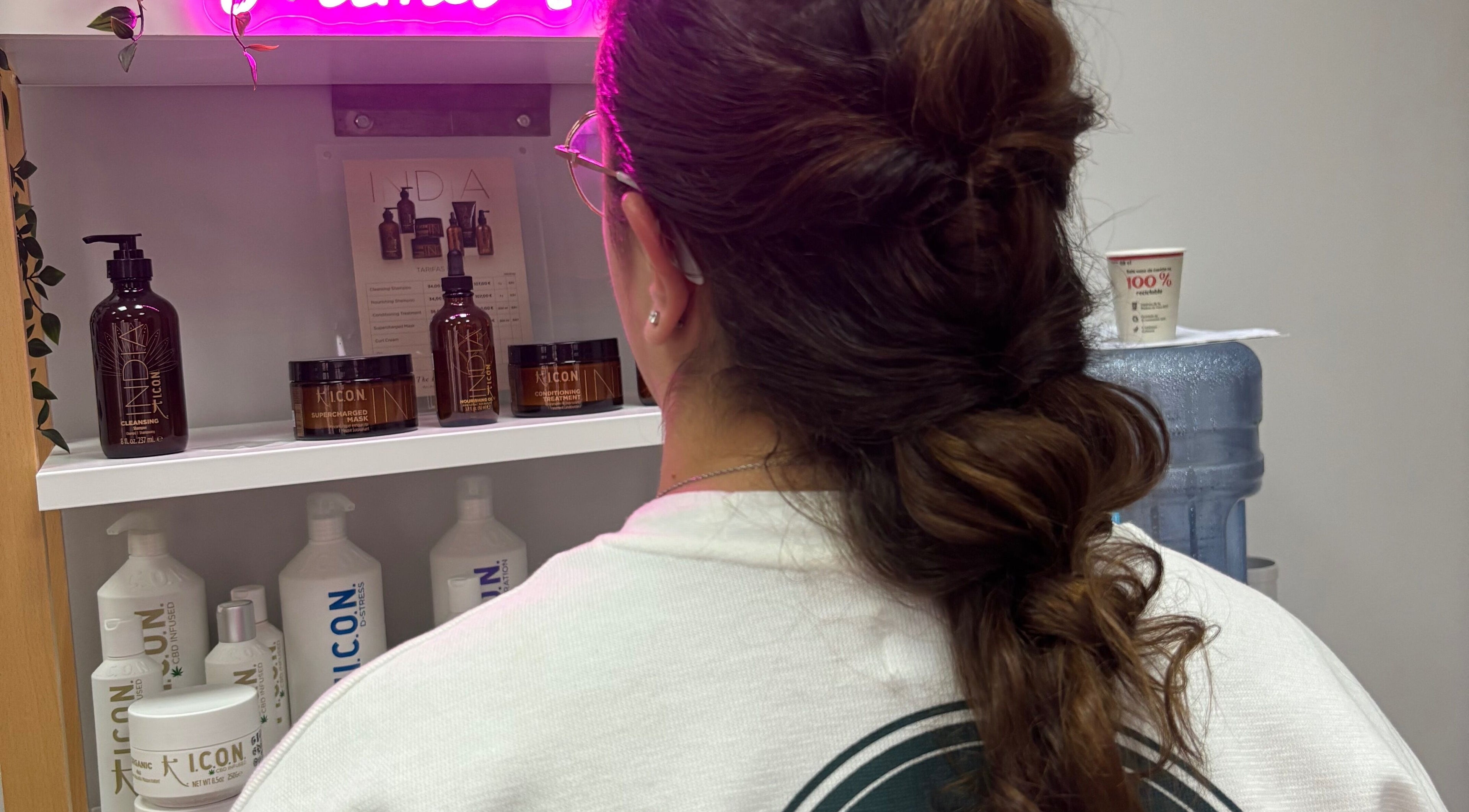 Mujer con elegante peinado frente a productos de belleza en Mima-T, Tarancón, Castilla-la Mancha, ES.