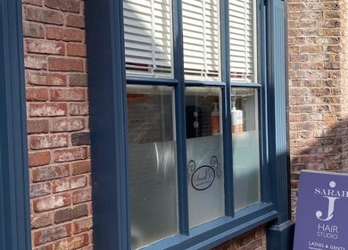 Exterior of Sarah J’s Hair Studio in Pocklington, England, GB featuring brick wall and signage.