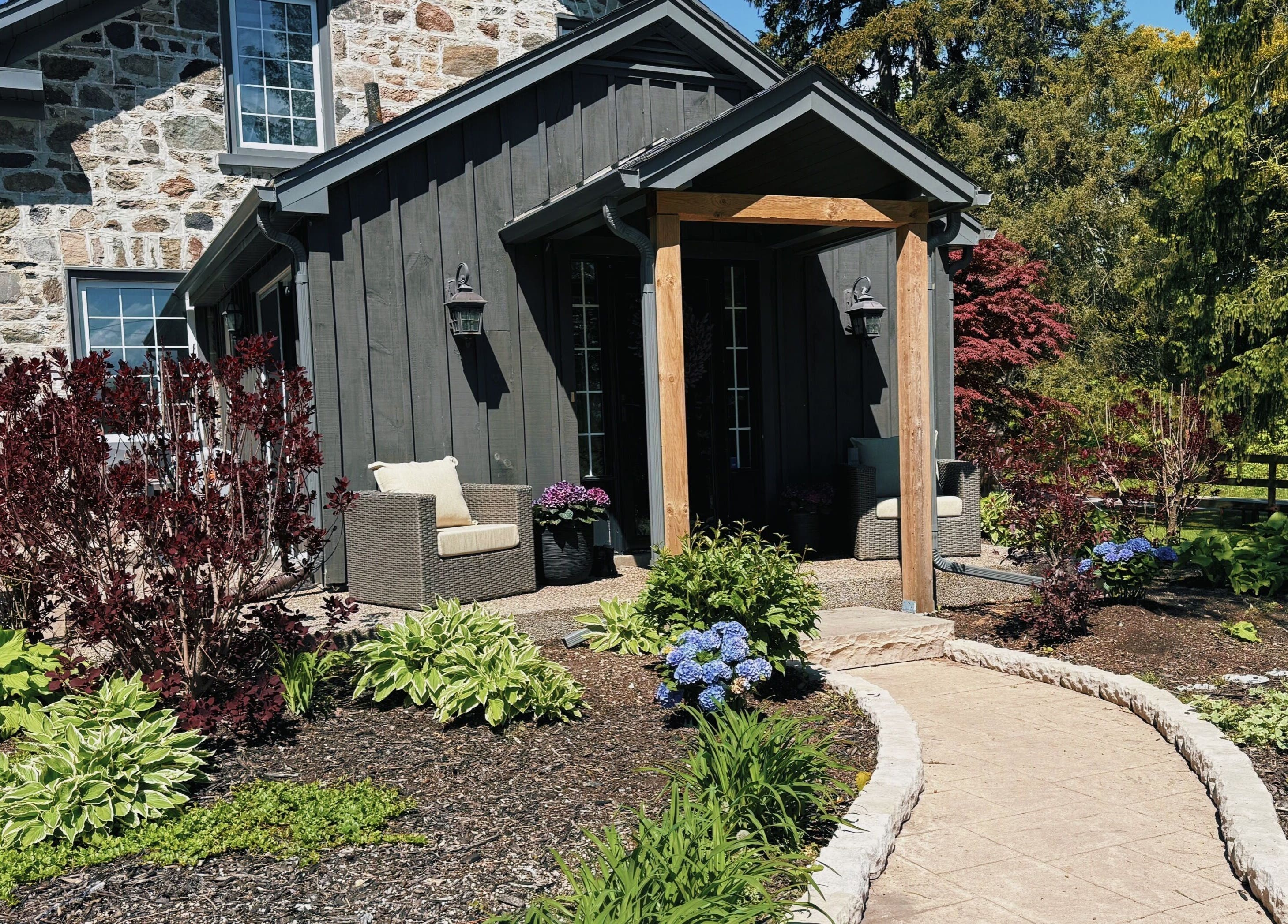 Charming garden view of Rhythm & Roots venue nestled in Ayr, Ontario, CA with lush plants and seating.