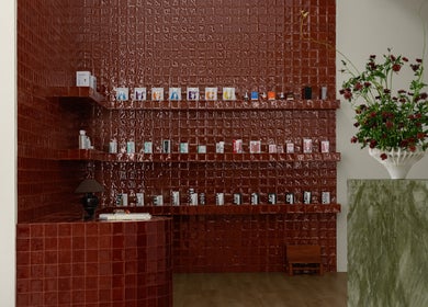 Elegant red tiled product display at Studio Julie Lemke, Dubai, Dubai, AE with lush floral arrangement.