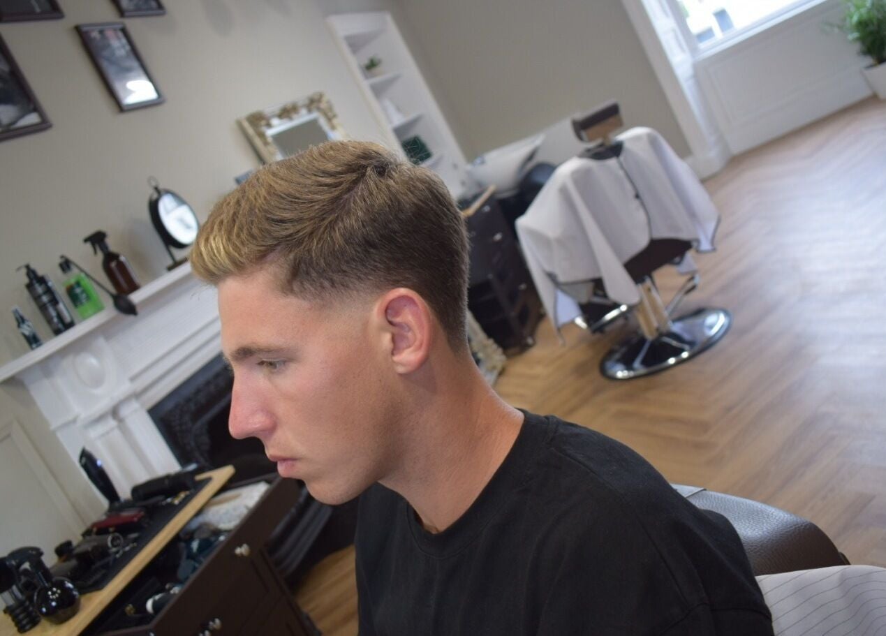 Client with stylish haircut at His Grooming, Ayr, Scotland, GB. Chic interior and professional tools visible.