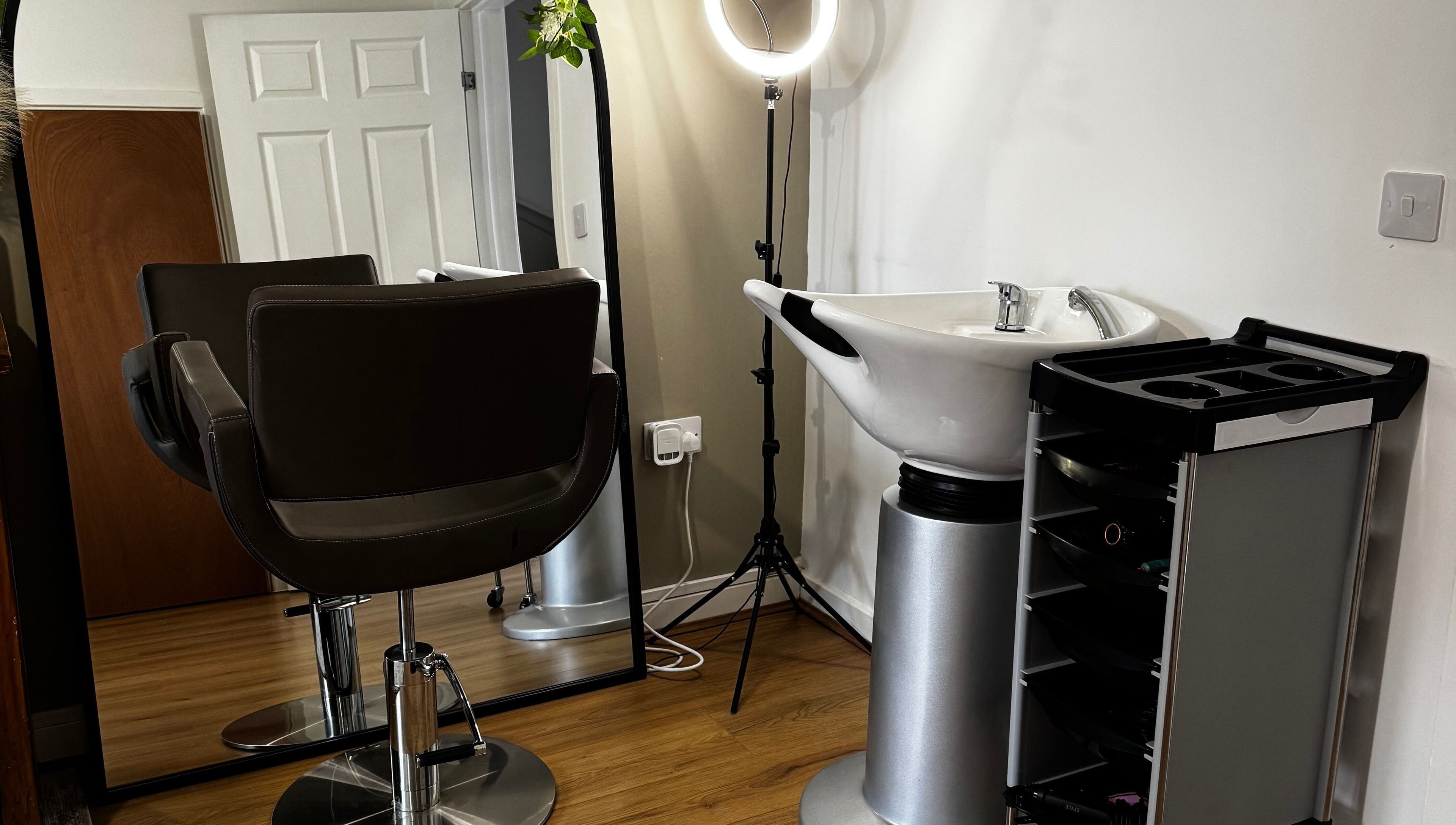 Modern salon setup at Luxe Locks, York, England, GB with styling chair, sink, and mirror.