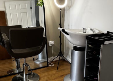 Modern salon setup at Luxe Locks, York, England, GB with styling chair, sink, and mirror.