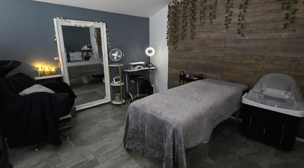Relaxing spa room at Loveli, Grangemouth, Scotland, GB with cozy massage table and serene decor.