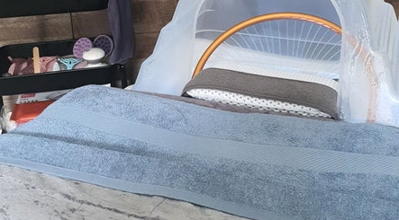 Cozy beauty treatment station at Loveli, Grangemouth, Scotland, GB, featuring a massage bed and spa tools.