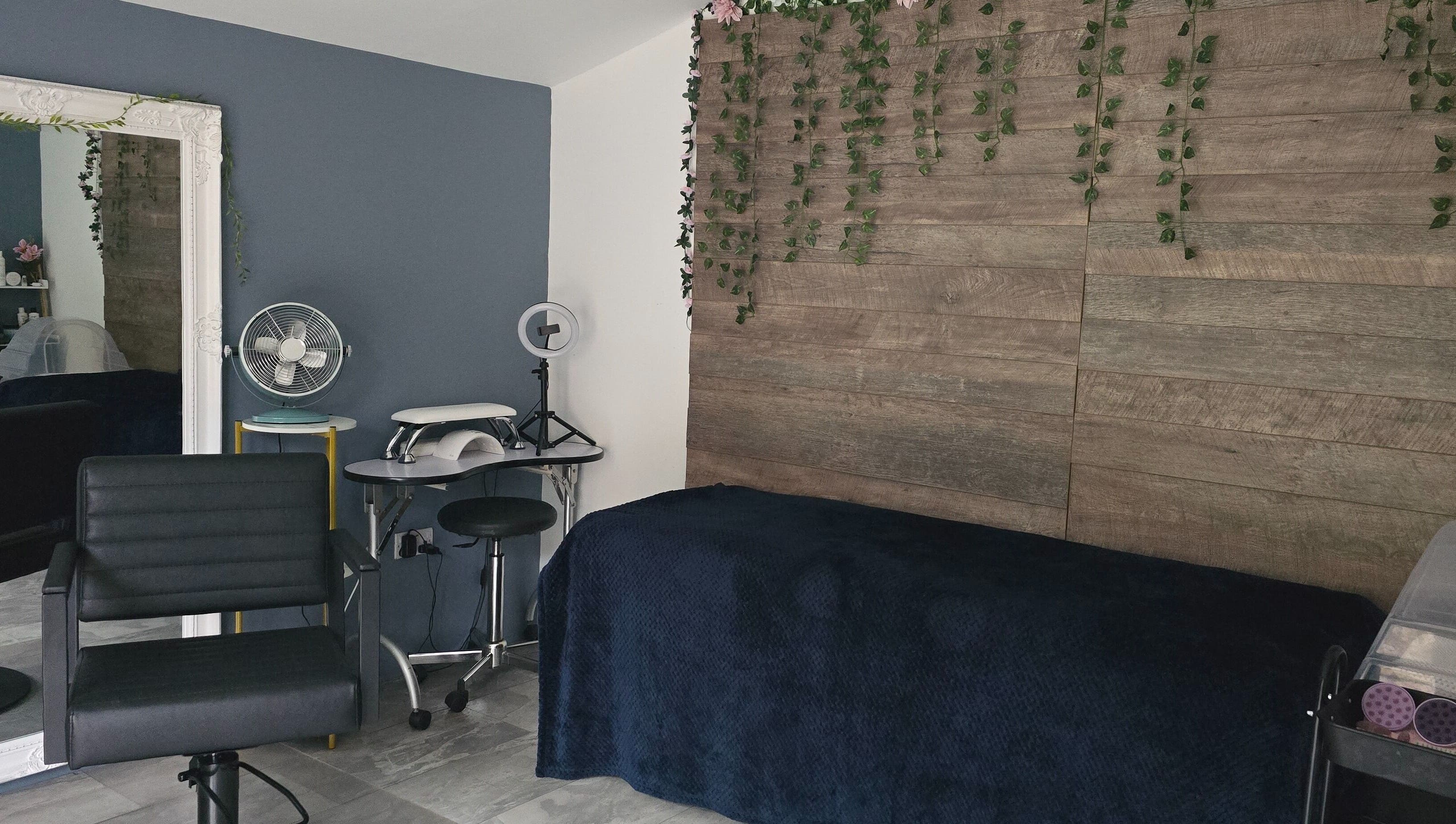 Modern beauty room at Loveli, Grangemouth, Scotland, GB, featuring sleek chair and rustic decor.