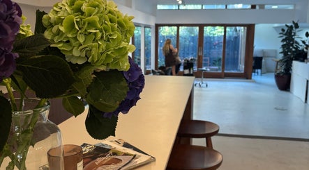 Gezellig interieur bij Stephanie Hair Artist, Amsterdam, Noord-Holland, NL. Bloemen en moderne stijl.