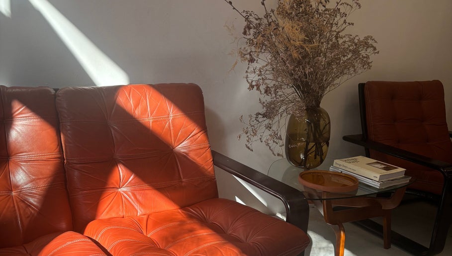 Stijlvolle vintage zithoek bij Stephanie Hair Artist, Amsterdam, Noord-Holland, NL, met gedroogde bloemen en boeken.