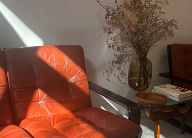Stijlvolle vintage zithoek bij Stephanie Hair Artist, Amsterdam, Noord-Holland, NL, met gedroogde bloemen en boeken.