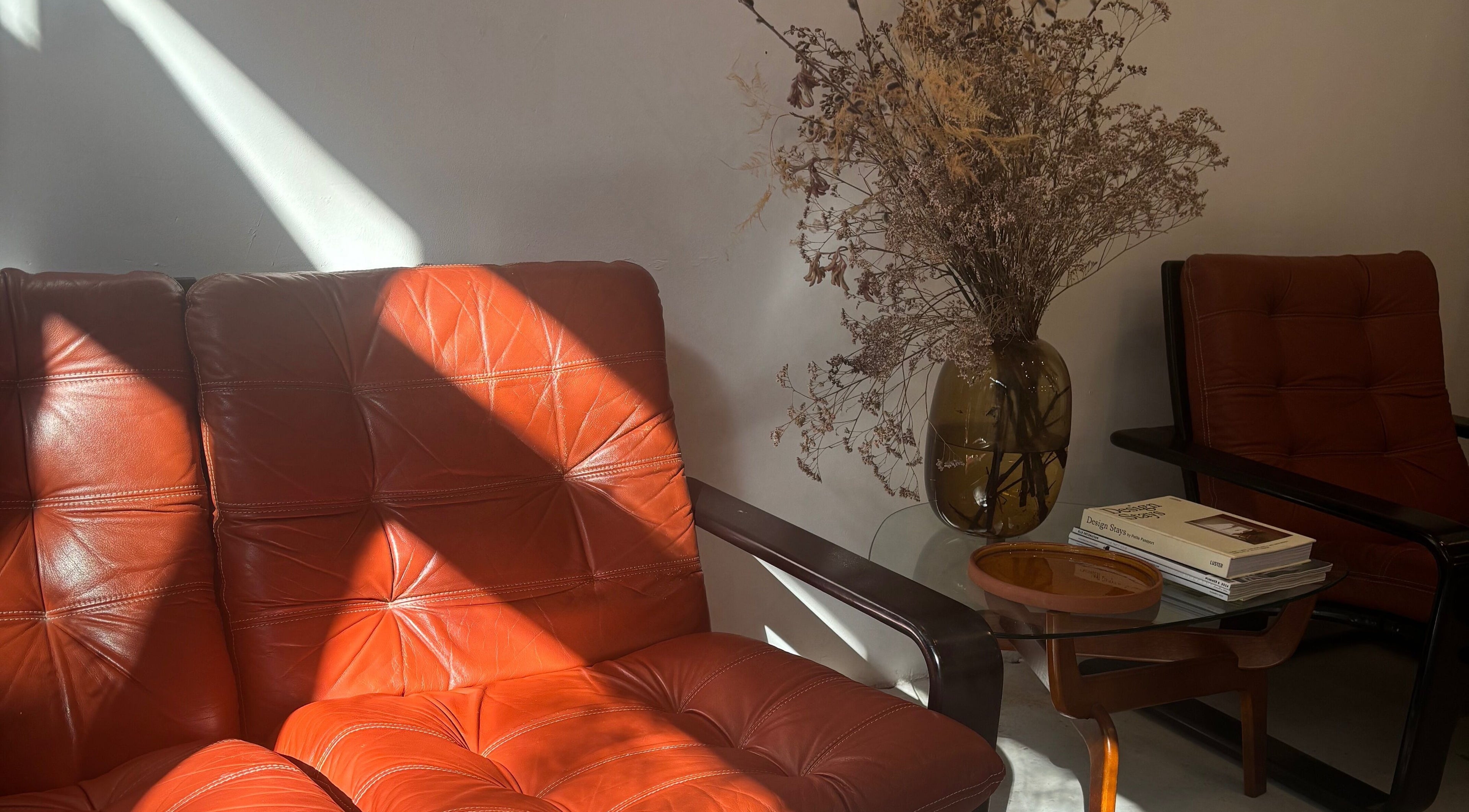 Stijlvolle vintage zithoek bij Stephanie Hair Artist, Amsterdam, Noord-Holland, NL, met gedroogde bloemen en boeken.