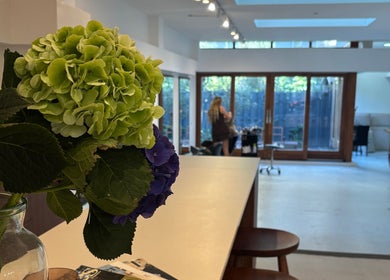 Lichte, ruime salon van Stephanie Hair Artist in Amsterdam, Noord-Holland, NL met prachtige bloemen op de voorgrond.