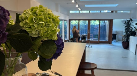 Lichte, ruime salon van Stephanie Hair Artist in Amsterdam, Noord-Holland, NL met prachtige bloemen op de voorgrond.