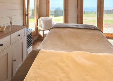 Peaceful treatment room at By Lana Grace, Ludgvan, England, GB with a cozy bed and scenic view.