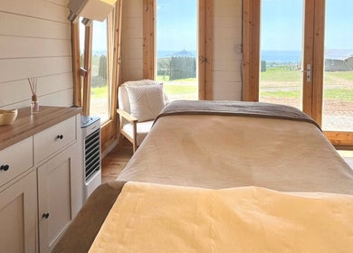 Tranquil therapy room at By Lana Grace, Ludgvan, England, GB with a relaxing bed and scenic views.