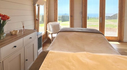 Tranquil therapy room at By Lana Grace, Ludgvan, England, GB with a relaxing bed and scenic views.