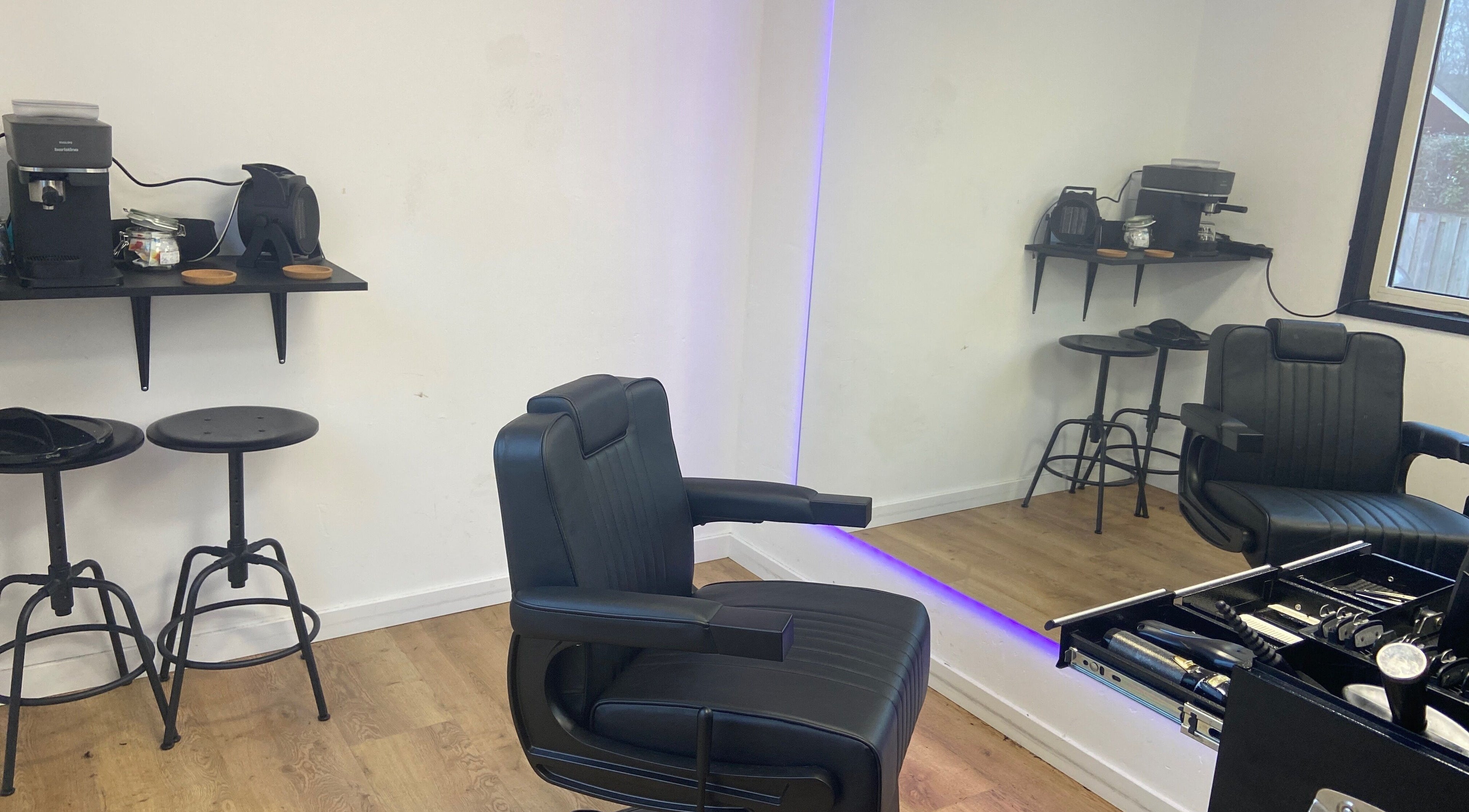 Elegante salonruimte bij HansHarold in Amsterdam, Noord-Holland, NL met moderne kappersstoel en werkplek.