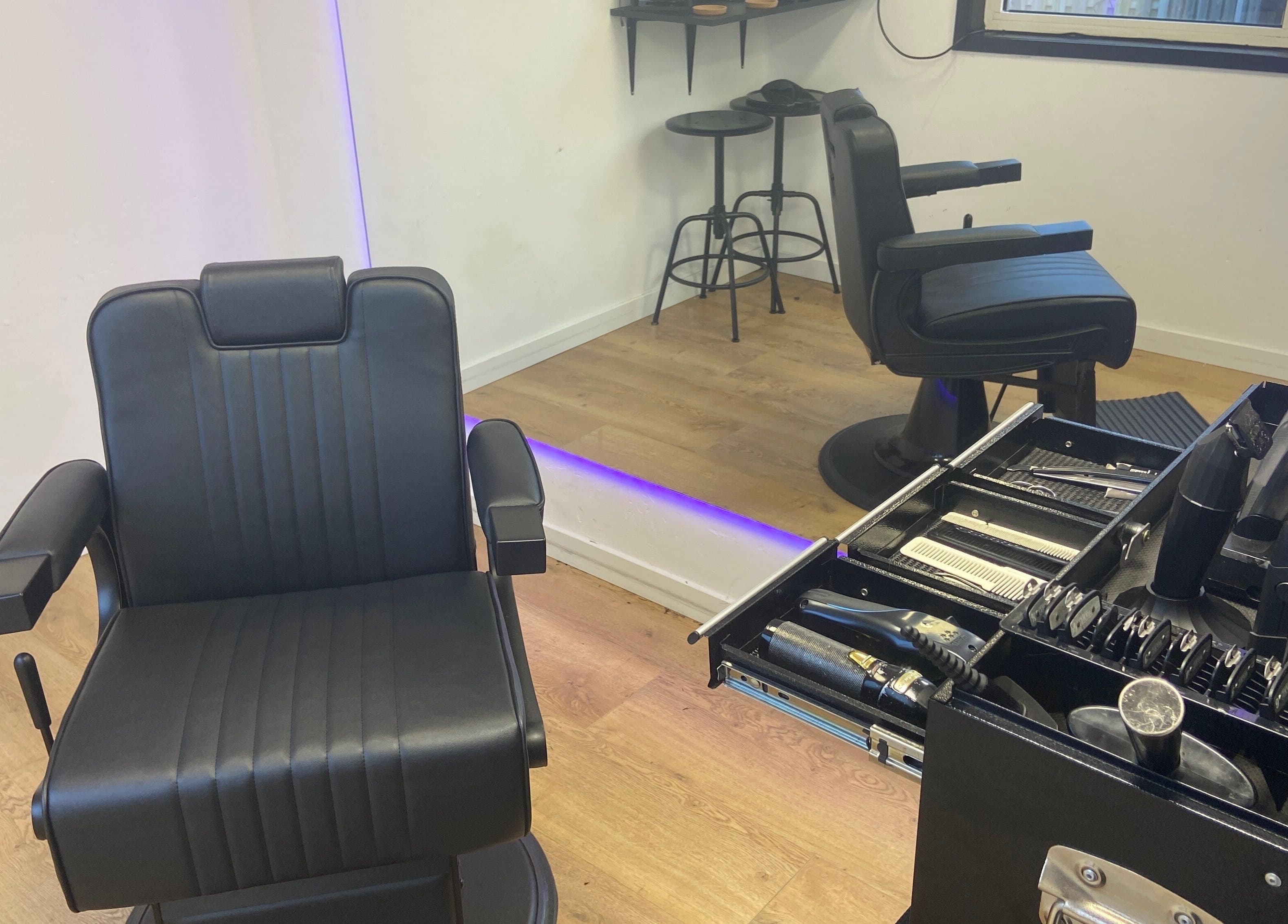 Interieur van HansHarold in Amsterdam, Noord-Holland, NL met luxe kappersstoel en spiegel.