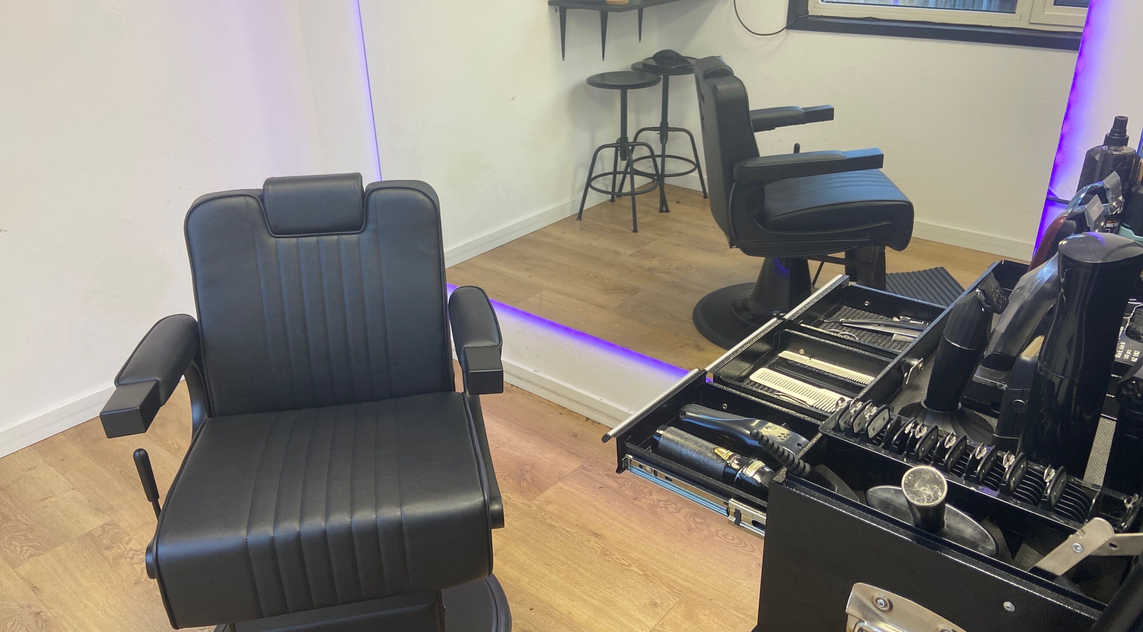 Interieur van HansHarold in Amsterdam, Noord-Holland, NL met luxe kappersstoel en spiegel.